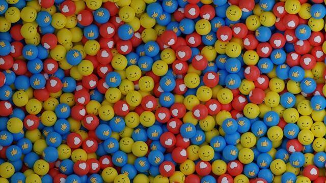 Colorful emoji balls featuring smiley faces, hearts, and thumbs-up reactions, representing digital communication and social media engagement.